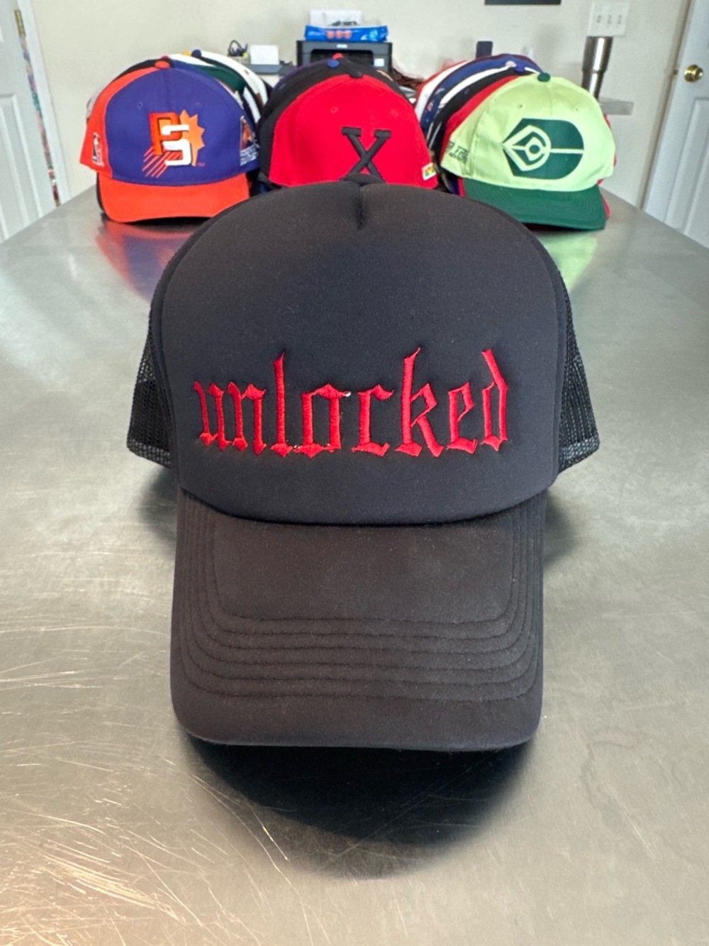 Black Trucker Hat with Red "unlocked" Embroidery